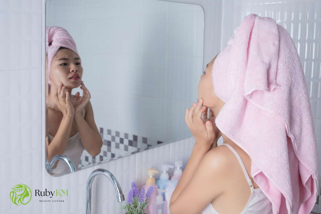 Woman checking acne-prone skin in the mirror