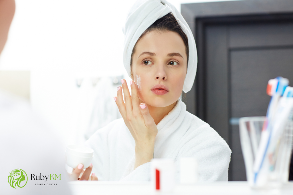 Woman applying moisturizer to her face as part of a skincare routine